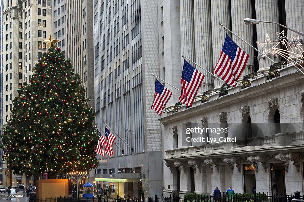New York, USA - December 27, 2011: The New York Stock Exchange at Wall Street with the American flags at the 1903 historic building and the famous Christmas tree in front of the building during the Christmas Holiday season.